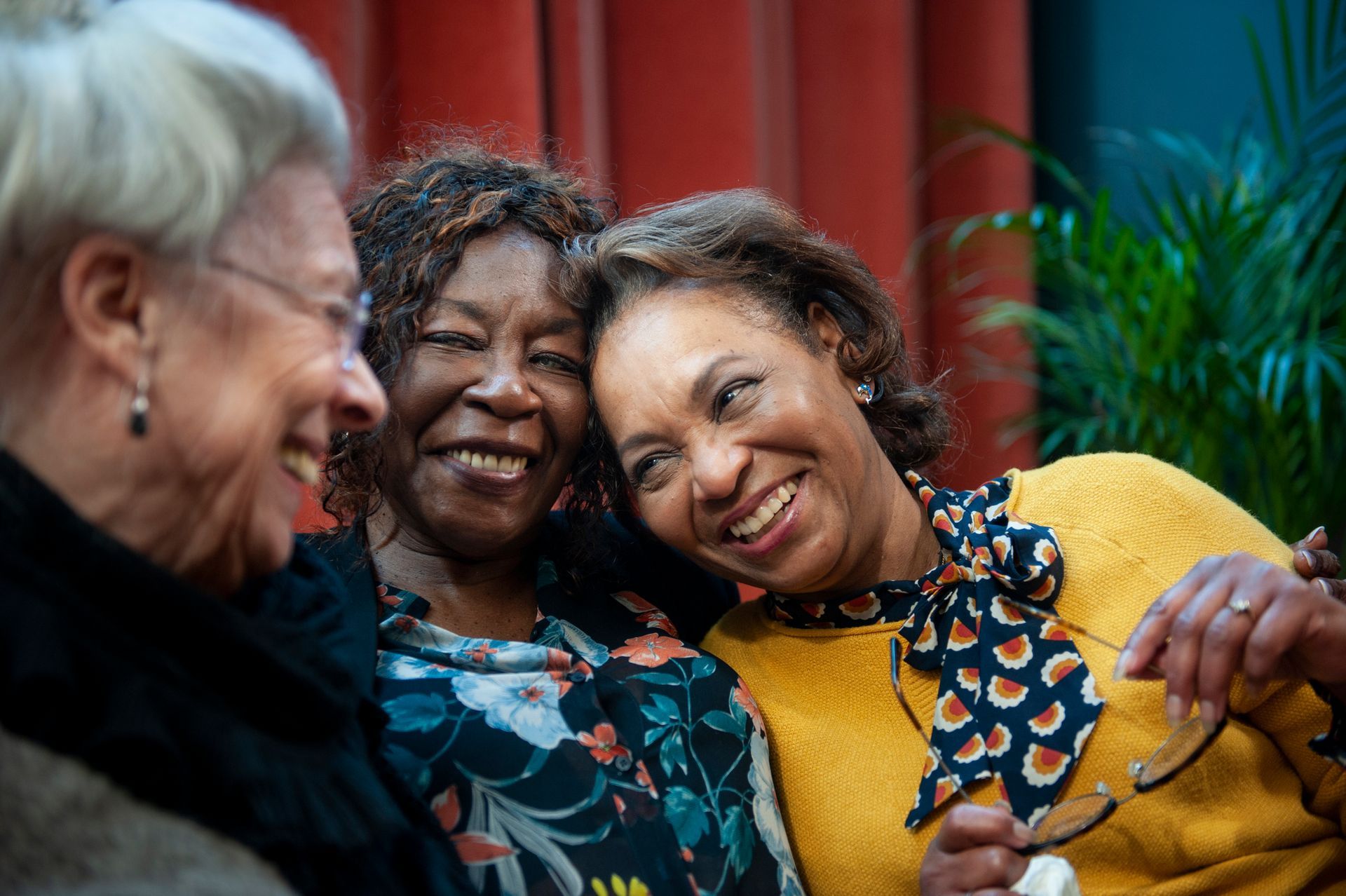 Three women smiling together.